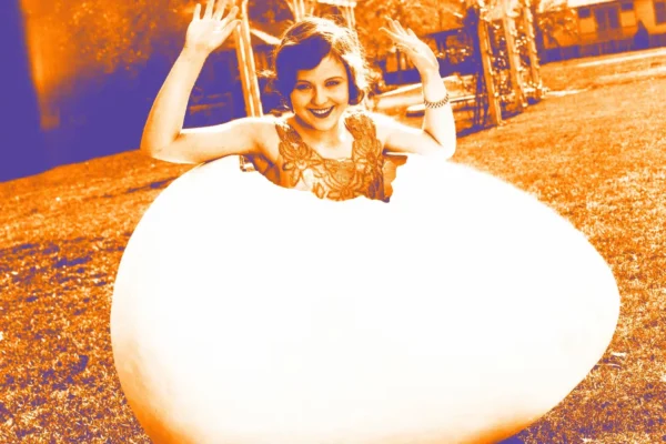 Woman sitting in giant egg