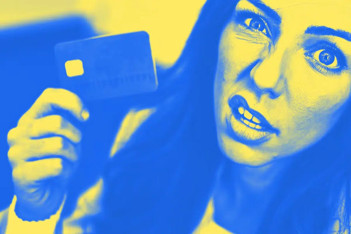 Woman grimacing holding credit card